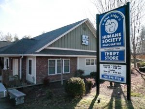 exterior view of a brick and tan siding building with a Blue Ridge Humane sign outside