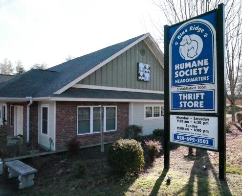 exterior view of a brick and tan siding building with a Blue Ridge Humane sign outside