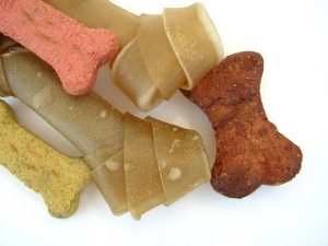 a pile of several types of dog treats all in bone shapes