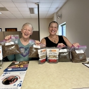Two people pose with treats, litter, and pet