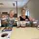 Two people pose with treats, litter, and pet