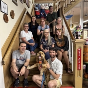 Several people pose with a dog on stairs