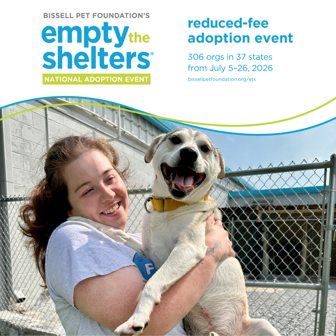A person holds a medium white dog
