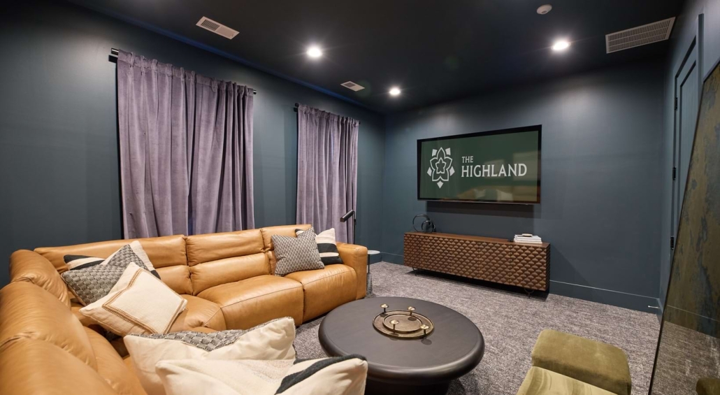 A couch in a room with a TV that says "The Highland"