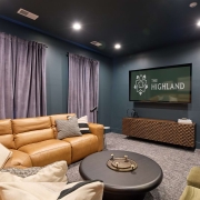 A couch in a room with a TV that says "The Highland"